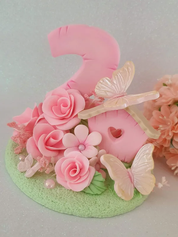 Topo de bolo em biscuit feito pela Teka: número 2 rosa com rosas e borboletas